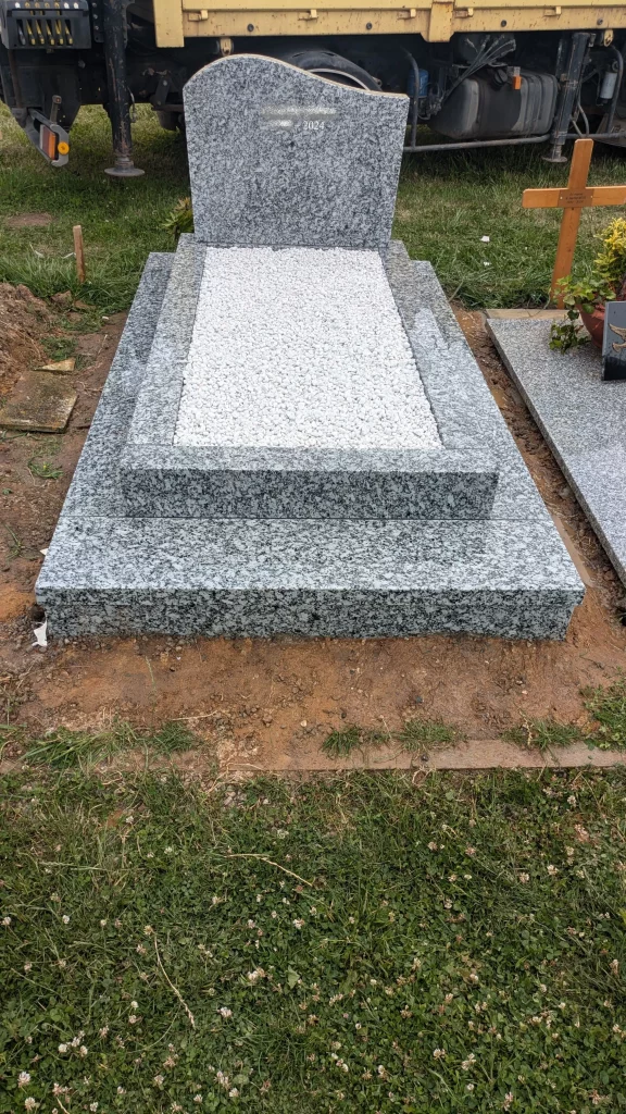 Monument funéraire en granit gris nouvellement installé dans un cimetière - Marbrerie Claudepierre