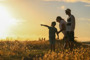 Famille en silhouette au coucher du soleil, symbole de soutien et d'espoir - Services Funéraires Claudepierre